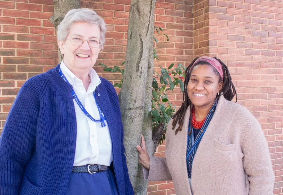 Sister Mary Jean Doyle (on the left) and Ryan Dunn Komeh (on the right) standing and smiling.