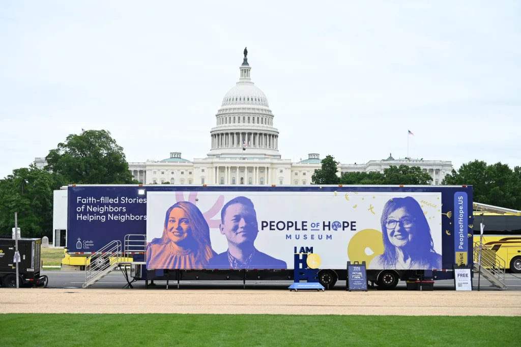 The 53-foot semi-tractor trailer truck with the words People of Hope Museum on it alongside images of three people smiling sits in front of the Capitol building in Washington, D.C.